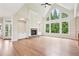 Open living room with hardwood floors, a fireplace, and tall windows offering beautiful views at 4508 Meadow Vista Trce, Lithonia, GA 30038