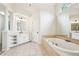 Bright main bathroom featuring a tub, shower, and vanity with storage at 4508 Meadow Vista Trce, Lithonia, GA 30038