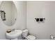 A simple white half-bathroom with a round mirror, toilet, and towel rack at 98 Concord Pl, Hiram, GA 30141
