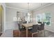 Bright dining room with modern light fixture, table with six chairs, and large window views at 98 Concord Pl, Hiram, GA 30141