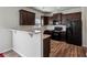 This kitchen features dark wood cabinets, granite countertops, bar and black appliances at 98 Concord Pl, Hiram, GA 30141