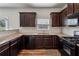 This kitchen features dark wood cabinets, granite countertops and black appliances at 98 Concord Pl, Hiram, GA 30141