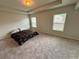 Spacious main bedroom with soft carpet, tray ceiling, and natural light from two windows at 98 Concord Pl, Hiram, GA 30141