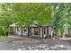 The exterior reveals a cozy cottage nestled amongst trees, featuring a covered porch for enjoying the scenery at 2155 Cove Trl, Cumming, GA 30041