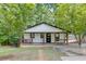 Charming cottage-style home with a cozy front porch and a well-maintained lawn surrounded by lush trees at 2155 Cove Trl, Cumming, GA 30041