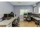 Office with two desks, gray wood floors, and natural light at 2155 Cove Trl, Cumming, GA 30041
