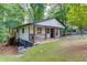Exterior view of the home showcasing a walkout basement, elevated porch, and serene, tree-filled surroundings at 2155 Cove Trl, Cumming, GA 30041