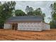 Partially constructed house with a protective wrap and exposed rafters on a partially cleared lot at 354 Spruill Bridge Rd, Temple, GA 30179