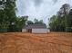 Under construction home features framing, sheathing and roofing on a large lot with partially cleared ground at 354 Spruill Bridge Rd, Temple, GA 30179