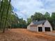 Exterior view of home with completed roof, protective wrap, on a large lot surrounded by trees at 354 Spruill Bridge Rd, Temple, GA 30179