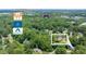 Aerial view shows a property near the Mall of Georgia, Coolray Field and entertainment venues, surrounded by dense trees at 837 Pine Ridge Dr, Lawrenceville, GA 30043