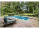 Backyard with a swimming pool surrounded by lush greenery and seating areas at 837 Pine Ridge Dr, Lawrenceville, GA 30043