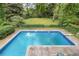 Backyard with a refreshing swimming pool surrounded by lush greenery and lawn at 837 Pine Ridge Dr, Lawrenceville, GA 30043