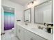 Bathroom featuring double sinks with a large countertop, framed mirrors, and an open doorway to the shower at 9117 Hanover St, Lithia Springs, GA 30122