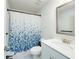 Bright bathroom featuring a toilet, vanity with mirror, and a shower/tub with blue patterned curtain at 9117 Hanover St, Lithia Springs, GA 30122