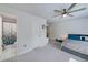 Comfortable bedroom featuring neutral gray carpet, ceiling fan, and en suite bathroom at 9117 Hanover St, Lithia Springs, GA 30122