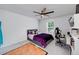 Well-lit bedroom featuring a ceiling fan, bed with purple comforter, desk, and a gaming chair at 9117 Hanover St, Lithia Springs, GA 30122