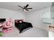 Bedroom featuring a ceiling fan, bed with black comforter, desk with computer, and a pink gaming chair at 9117 Hanover St, Lithia Springs, GA 30122