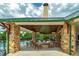 A covered outdoor gathering space with stone pillars and a central fire pit at 9117 Hanover St, Lithia Springs, GA 30122