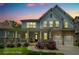Charming two-story home with stone accents, a welcoming porch, and a well-manicured lawn at dusk at 9117 Hanover St, Lithia Springs, GA 30122