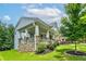 A beautiful, modern home with a stone foundation, large front porch, and lush, green landscaping at 9117 Hanover St, Lithia Springs, GA 30122