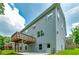 Back exterior view featuring a wooden deck, concrete patio, a grey siding and a door at 9117 Hanover St, Lithia Springs, GA 30122