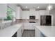 Bright kitchen boasts white cabinets, stainless steel appliances, quartz countertops and a window view at 9117 Hanover St, Lithia Springs, GA 30122