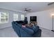 Bright living room with large sofa, entertainment center, and lots of natural light from the windows at 9117 Hanover St, Lithia Springs, GA 30122
