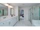 Bright main bathroom featuring double sinks, tile floors, and a glass-enclosed shower at 9117 Hanover St, Lithia Springs, GA 30122