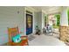 Charming front porch with a rocking chair, a welcome mat, and a stylish blue front door at 9117 Hanover St, Lithia Springs, GA 30122