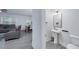 Modern powder room with gray walls, pedestal sink, and a nearby living room at 9117 Hanover St, Lithia Springs, GA 30122
