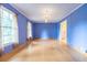 Spacious living room with hardwood floors, crown molding, blue walls, and large windows at 1236 S Shadygrove Ct, Stone Mountain, GA 30083