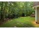 Spacious backyard featuring lush green lawn and a covered metal shelter perfect for outdoor equipment at 820 Airline Rd, Mcdonough, GA 30252