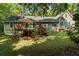 Back of house featuring a wood deck perfect for outdoor seating, surrounded by a lush, green lawn at 820 Airline Rd, Mcdonough, GA 30252