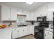 Well-lit kitchen with white cabinets, black appliances, and durable countertops at 820 Airline Rd, Mcdonough, GA 30252