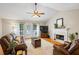 Cozy living room with hardwood floors, a white fireplace, and plush leather seating under a ceiling fan at 820 Airline Rd, Mcdonough, GA 30252