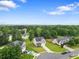 An aerial view showcases a charming home with a lush lawn in a tranquil, tree-lined neighborhood at 140 Canyons Ct, Hampton, GA 30228