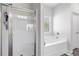 Bright bathroom featuring a glass shower door and separate soaking tub with tile flooring at 140 Canyons Ct, Hampton, GA 30228