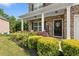 Inviting front porch with stone accents and a beautiful landscape with a colorful flower bed at 140 Canyons Ct, Hampton, GA 30228
