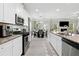 Well-equipped kitchen with stainless steel appliances and view into dining area and living area at 140 Canyons Ct, Hampton, GA 30228