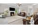 Cozy living room featuring a fireplace, ceiling fan and comfortable leather furniture at 140 Canyons Ct, Hampton, GA 30228