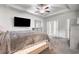 Bright main bedroom with tray ceilings, fan, flat screen TV, and ensuite bathroom entrance at 140 Canyons Ct, Hampton, GA 30228