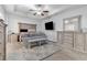 Spacious main bedroom with tray ceilings, a ceiling fan, TV, and luxury furnishings at 140 Canyons Ct, Hampton, GA 30228
