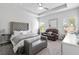 Bright main bedroom with a tufted headboard, ceiling fan, and lots of natural light at 140 Canyons Ct, Hampton, GA 30228