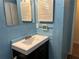 Cozy bathroom featuring a white vanity sink, matching mirror, and blue painted walls at 1455 Stone Mill Trce, Stone Mountain, GA 30083