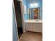 Bathroom featuring single vanity, mirror, and walk-in closet at 1455 Stone Mill Trce, Stone Mountain, GA 30083