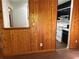 View of a kitchen with wood paneling, a white appliance, and black cabinets with white countertops at 1455 Stone Mill Trce, Stone Mountain, GA 30083