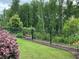 Landscaped backyard with black metal fence and lush green trees at 1790 Nestledown Dr, Cumming, GA 30040