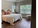 Bedroom with decorative headboard, patterned bedding, and a sunny window at 1790 Nestledown Dr, Cumming, GA 30040