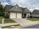 Charming home features a two-car garage, brick accents, and well-maintained landscaping at 1790 Nestledown Dr, Cumming, GA 30040